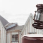 Gavel and houses on building construction site auction