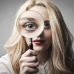 Young woman holding up a magnifying glass
