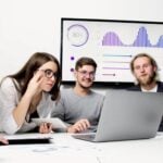 Employees looking at a presentation on a laptop