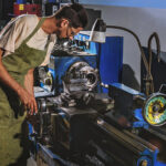 Side view of male manufacture worker in protective apron