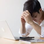 Stressed man leaning forward on a desk