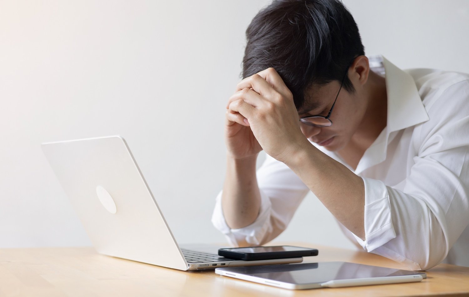 Stressed man leaning forward on a desk