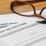 Accident report application form and pen on brown envelope