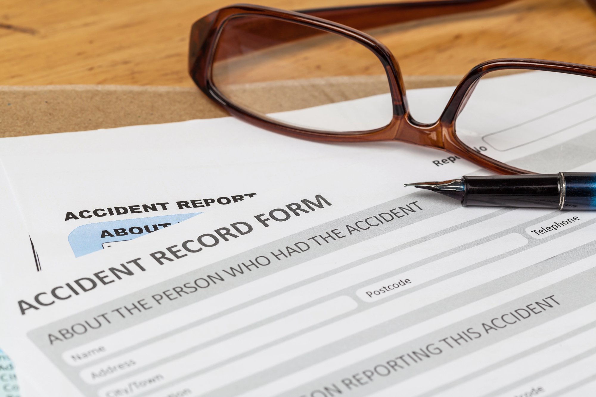 Accident report application form and pen on brown envelope