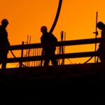 Construction workers working during sunset