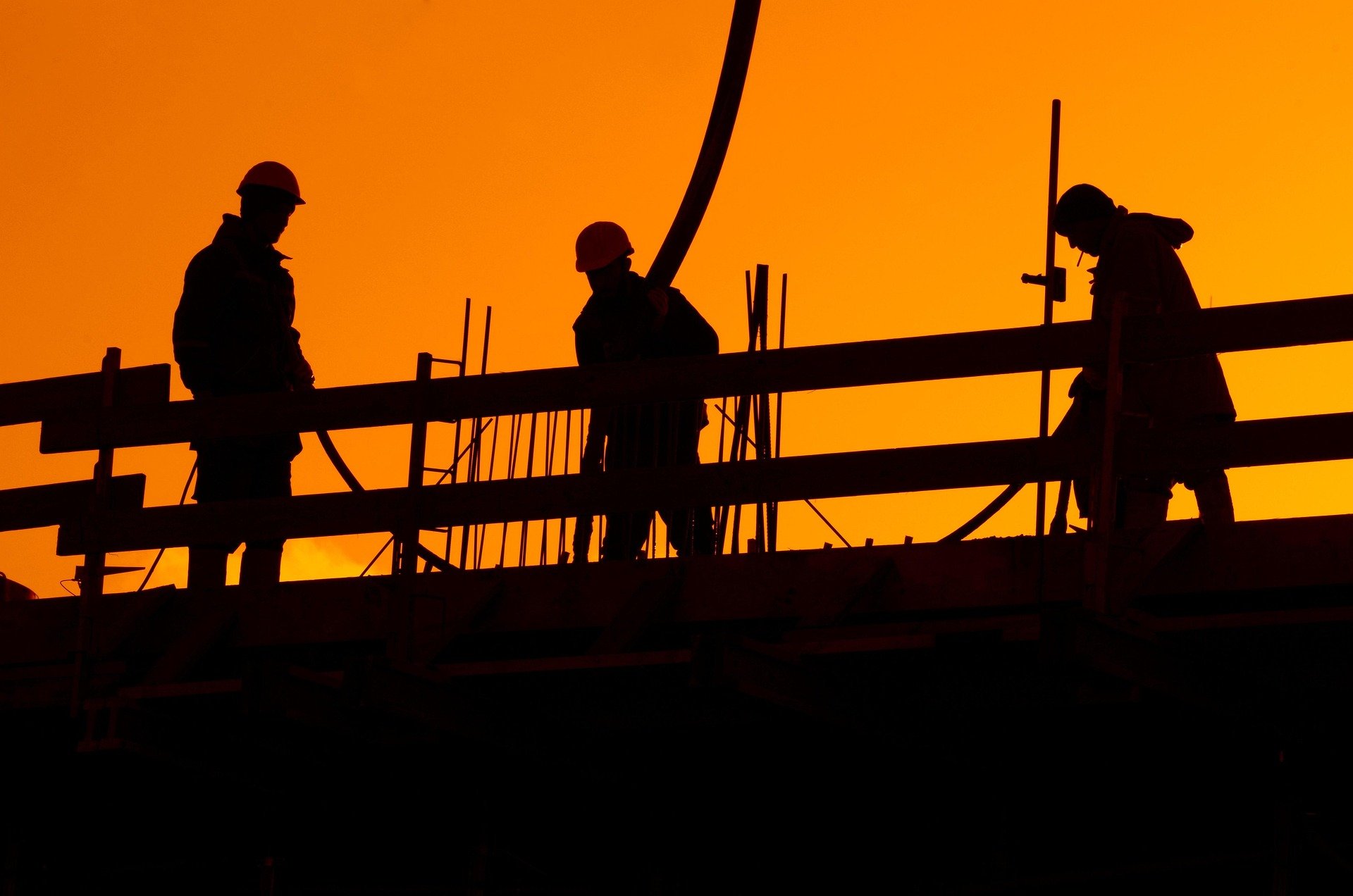 Construction workers working during sunset