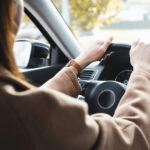 Cropped of woman driving car on blurred foreground