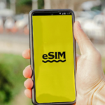 Man holding a smartphone that says eSIM