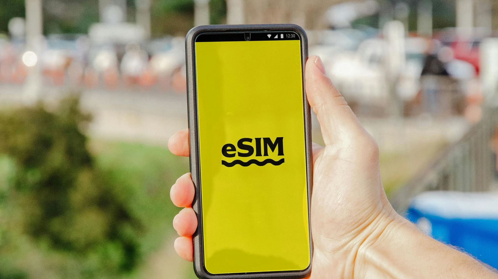 Man holding a smartphone that says eSIM