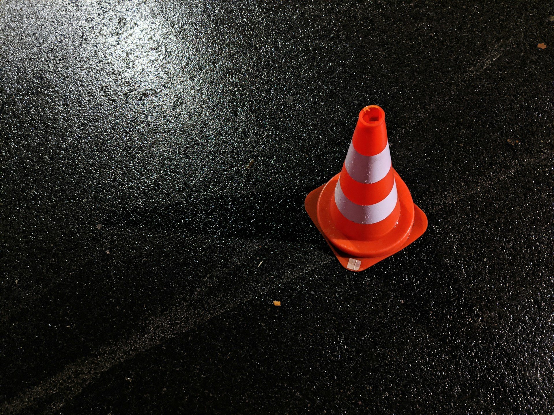 Orange and white traffic cone on street