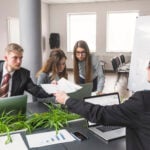 Businessman giving document to his colleague at workplace
