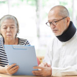 Elderly couple looking at the results of a neck injury