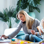 Flexible Work Laws: Improve the Lives of Parents Juggling Work and Personal Life 9 Mom working at home on couch with child playing next to her