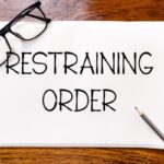 Restraining order written on whiteboard with glasses