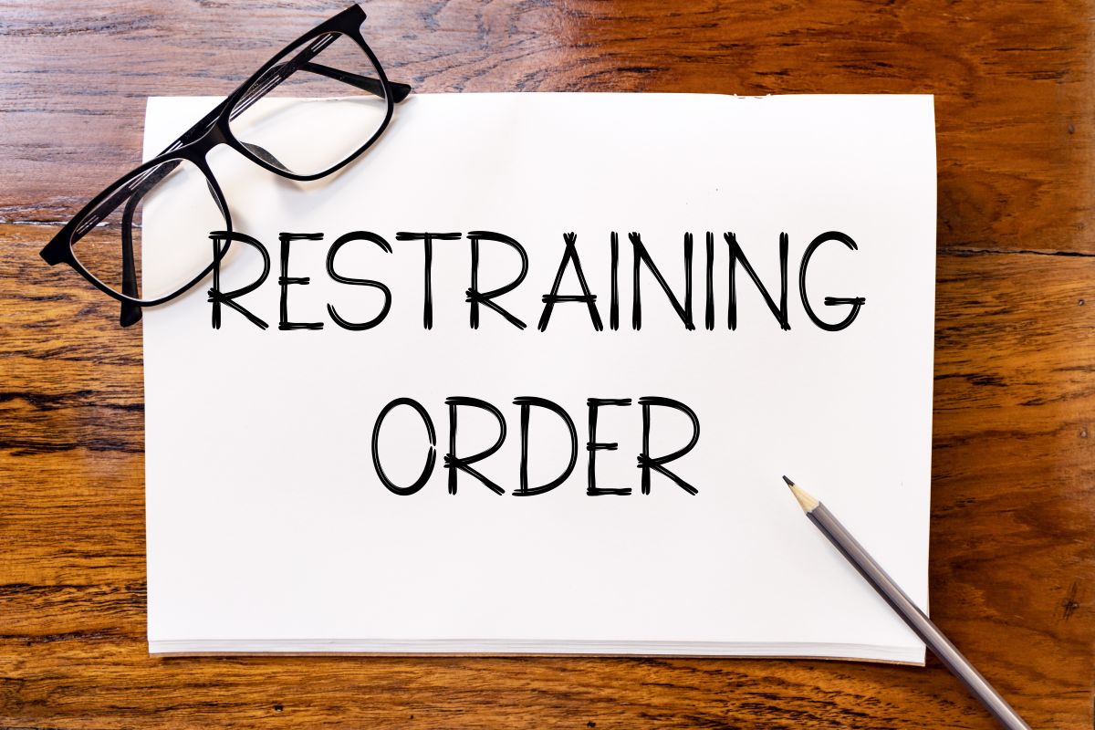 Restraining order written on whiteboard with glasses