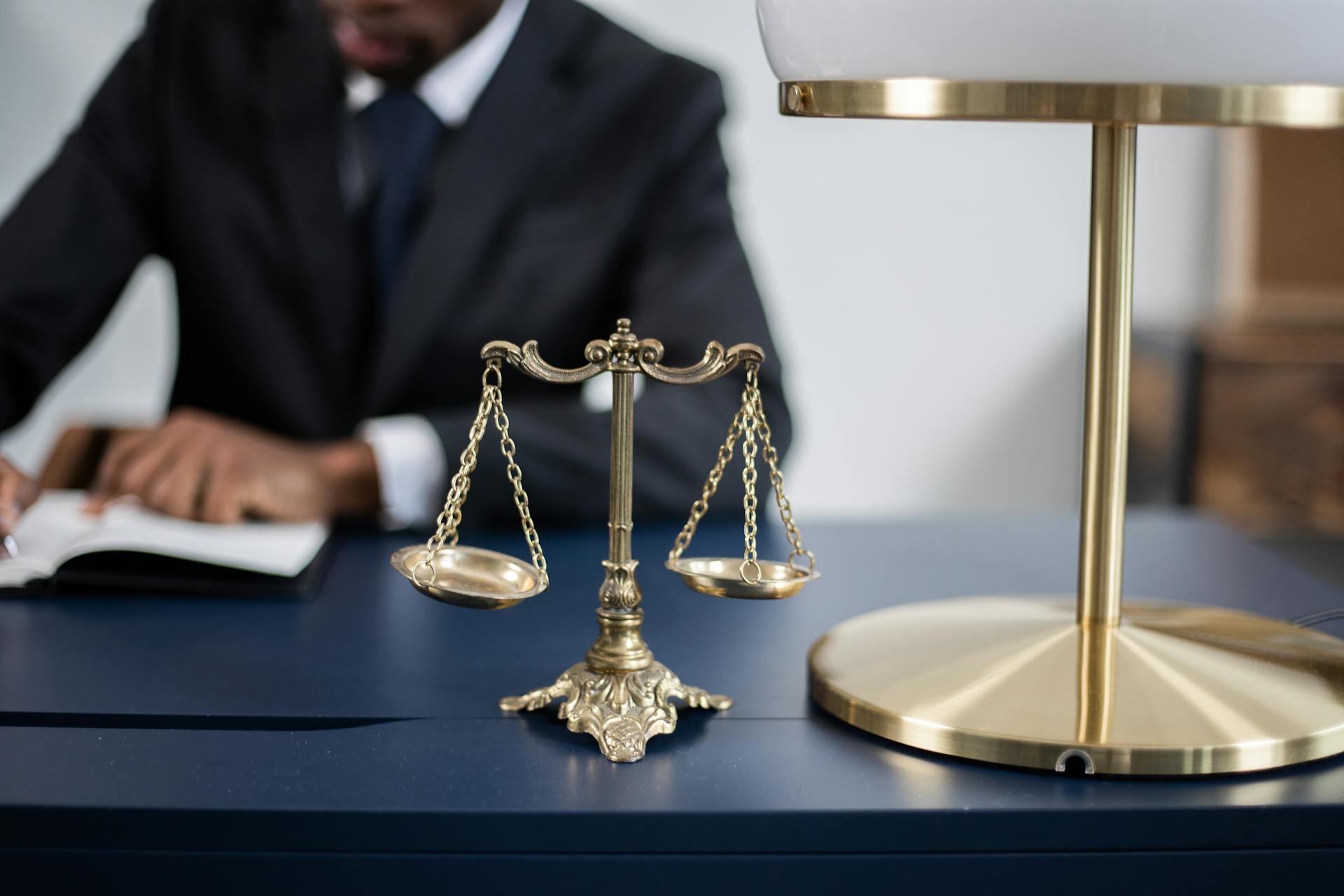 Scale of justice with attorney in the background