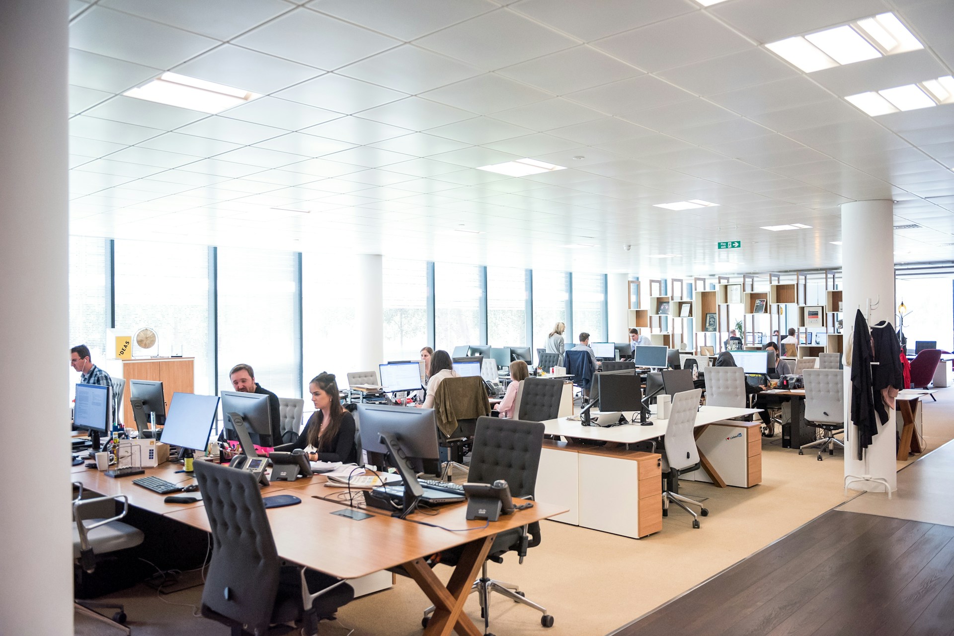 Open office with employees around a rectangular brown wooden table