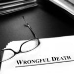 Wrongful death papers on desk with glasses for legal services