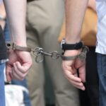 two people holding hands with handcuffs on them