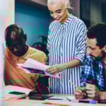 Cheerful female leader of working multiracial group
