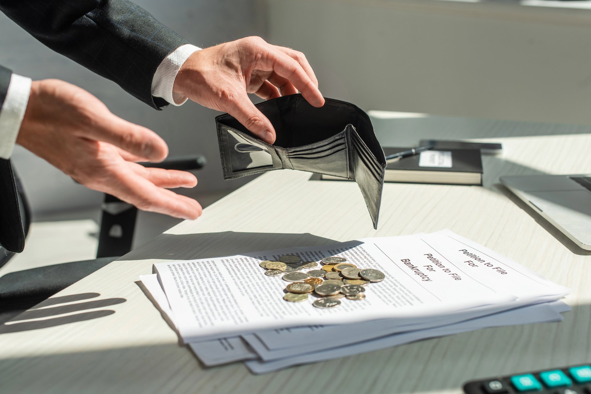 Cropped view of businessman holding empty wallet near coins