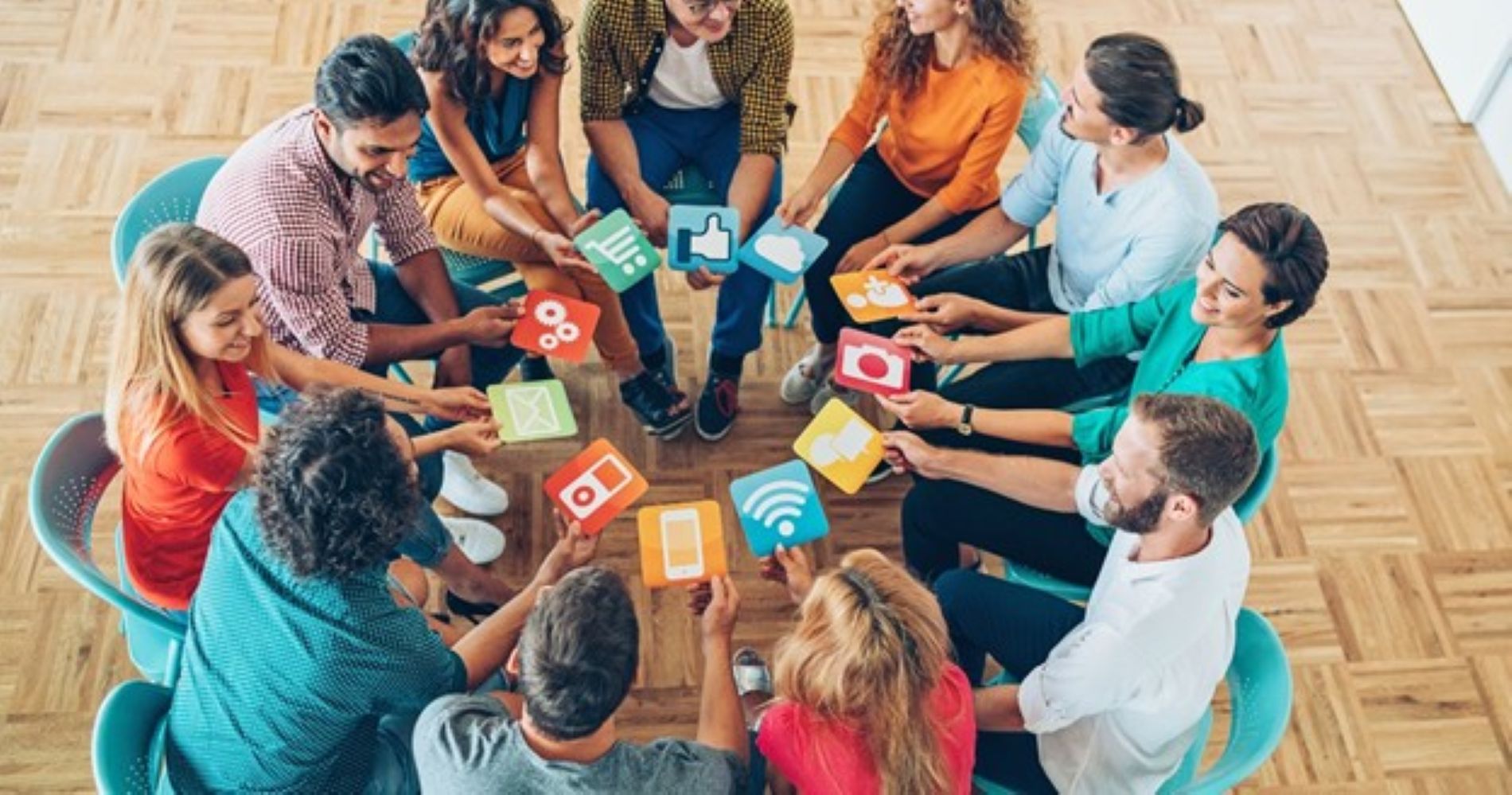 Employees sitting in a circle holding social media signs