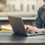 Man using a laptop on an outdoor table