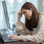 women working on laptop with stressed expression, concept of work pressure, burnout, remote job stress, overwork, or mental fatigue in modern work from home lifestyle.