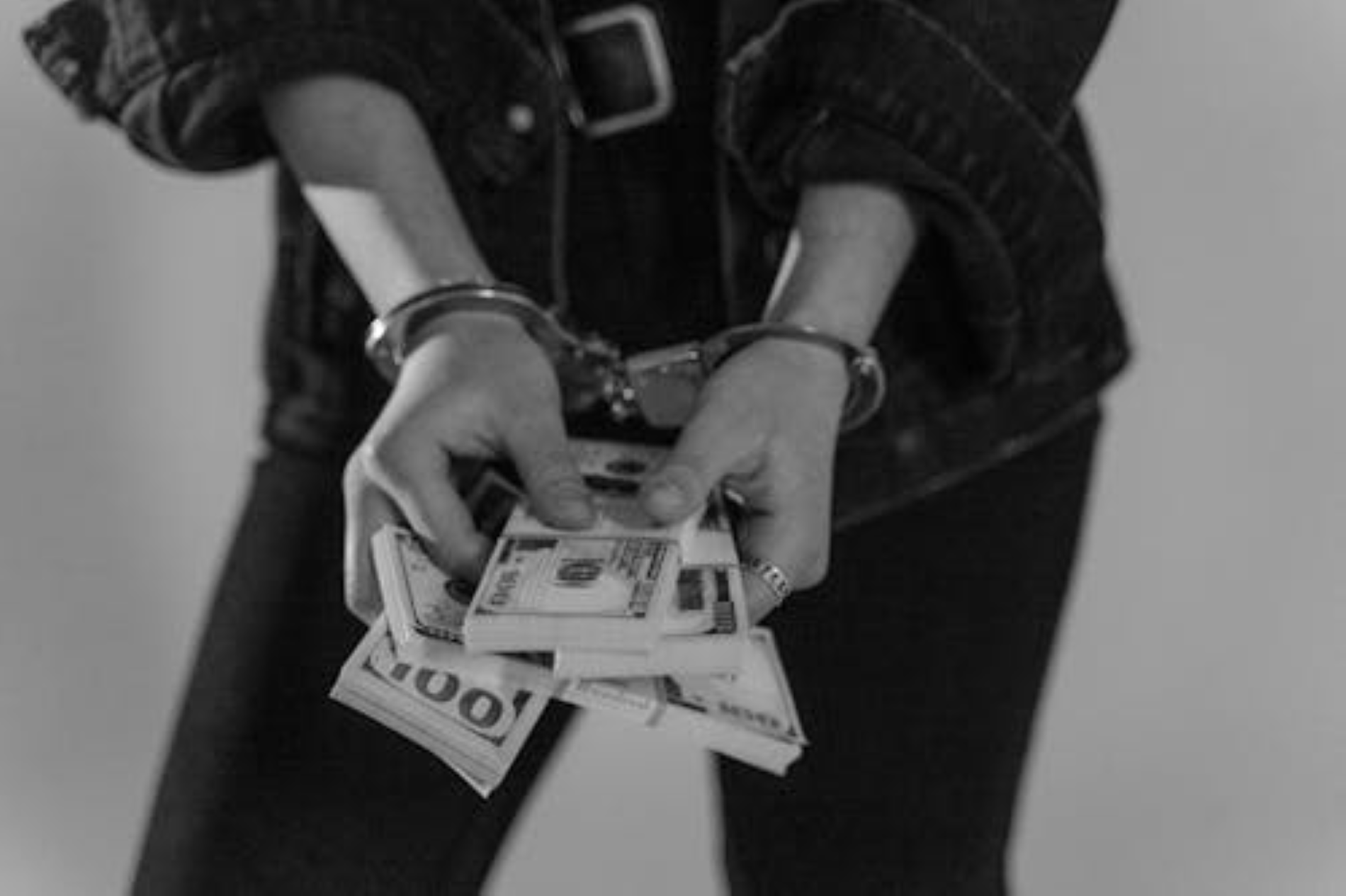 Woman in handcuffs holding cash
