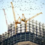 low angle photography of cranes on top of building