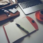 Notebook next to a laptop and purse