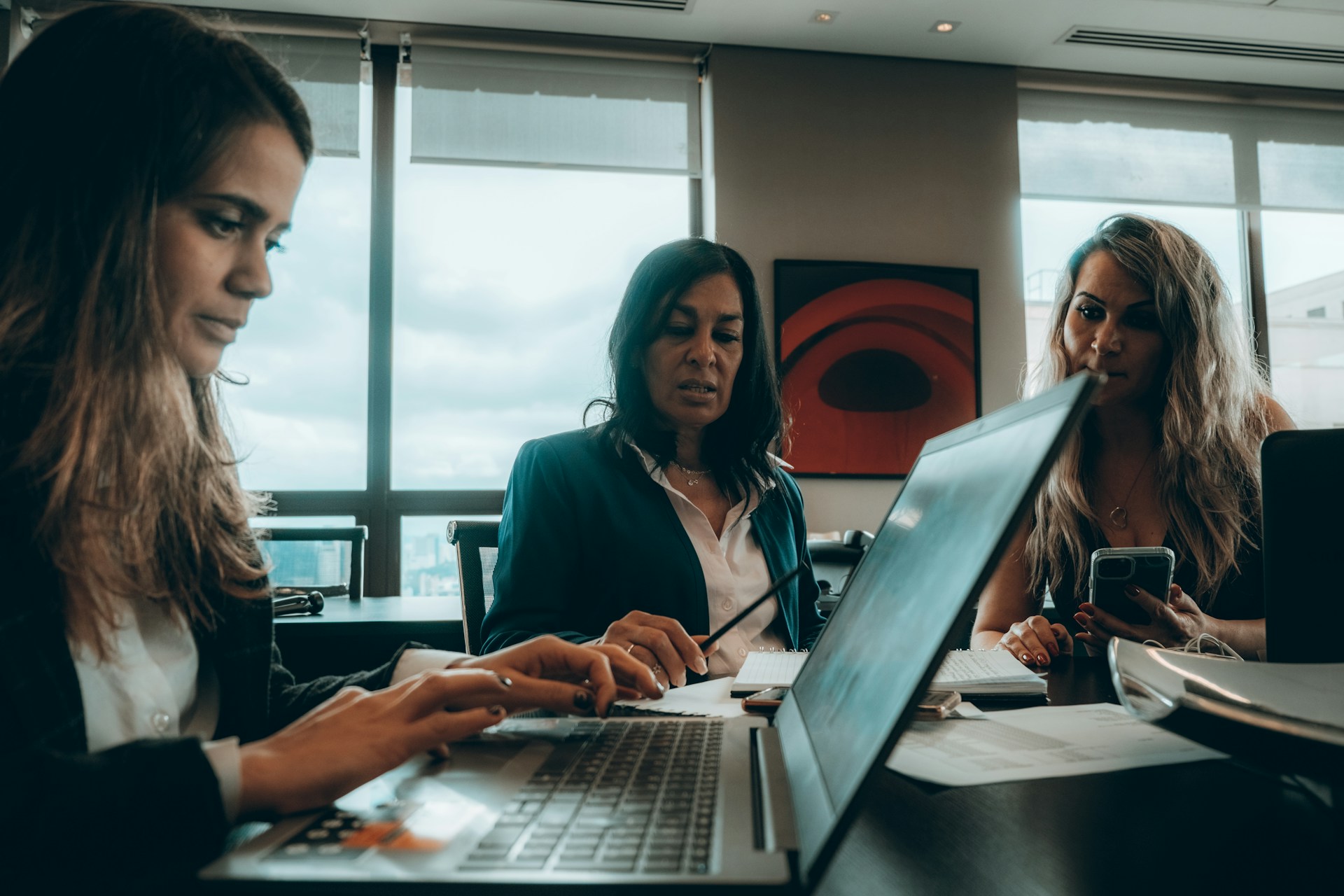 a group of women sitting around a laptop computer