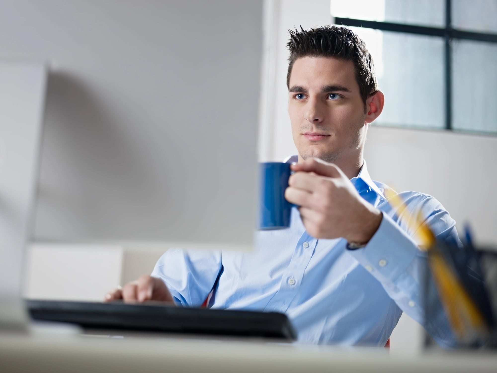 Businessman drinking coffee in office