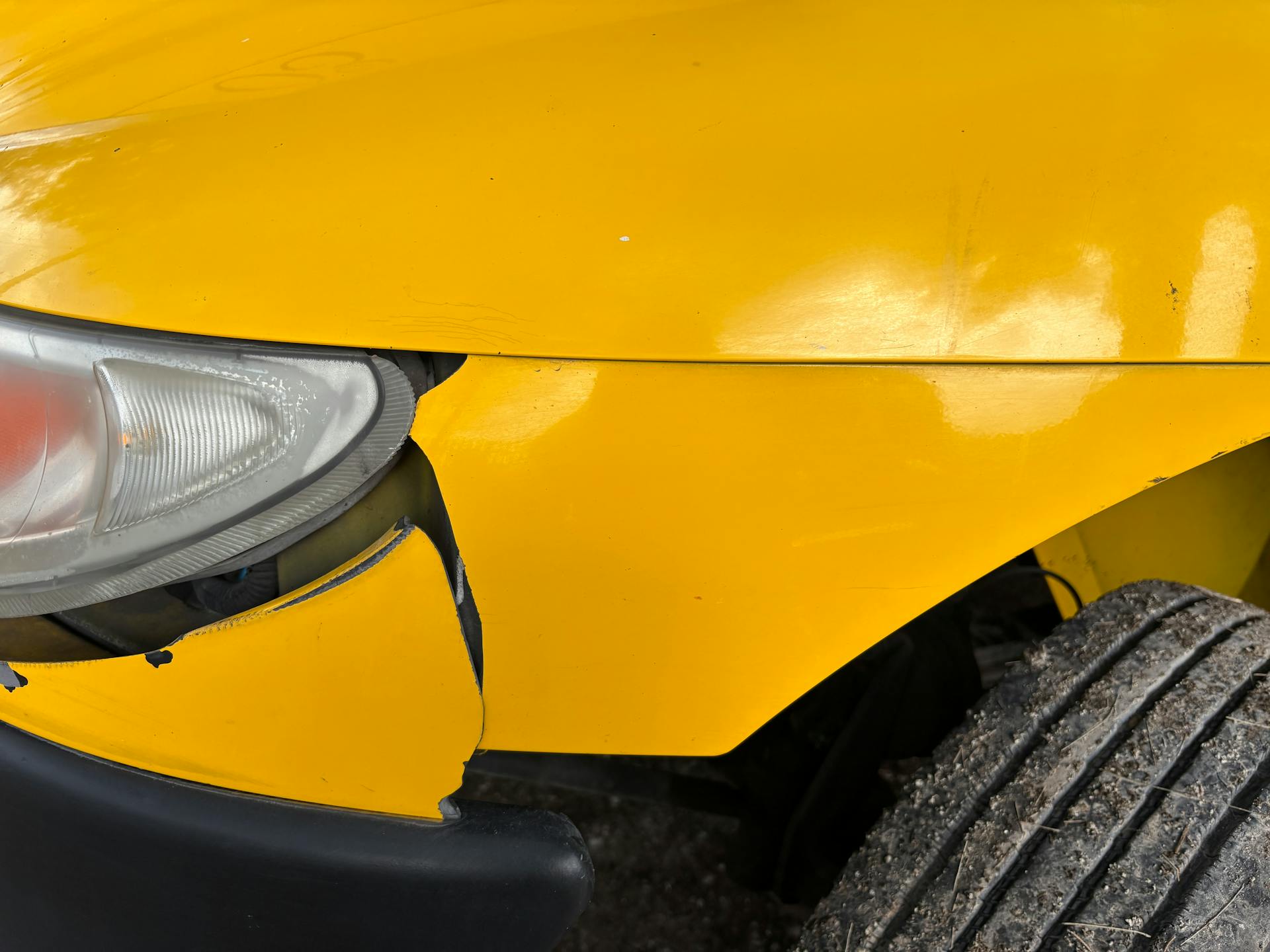 Close-up of Damaged Yellow Car Front Bumper