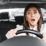 Frightened woman screaming while driving car