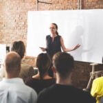 Best Compliance Training Software With Built-In Audit Trails (2026) 11 People at conference with blank board