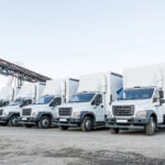Five new white trucks ready for departure are parked