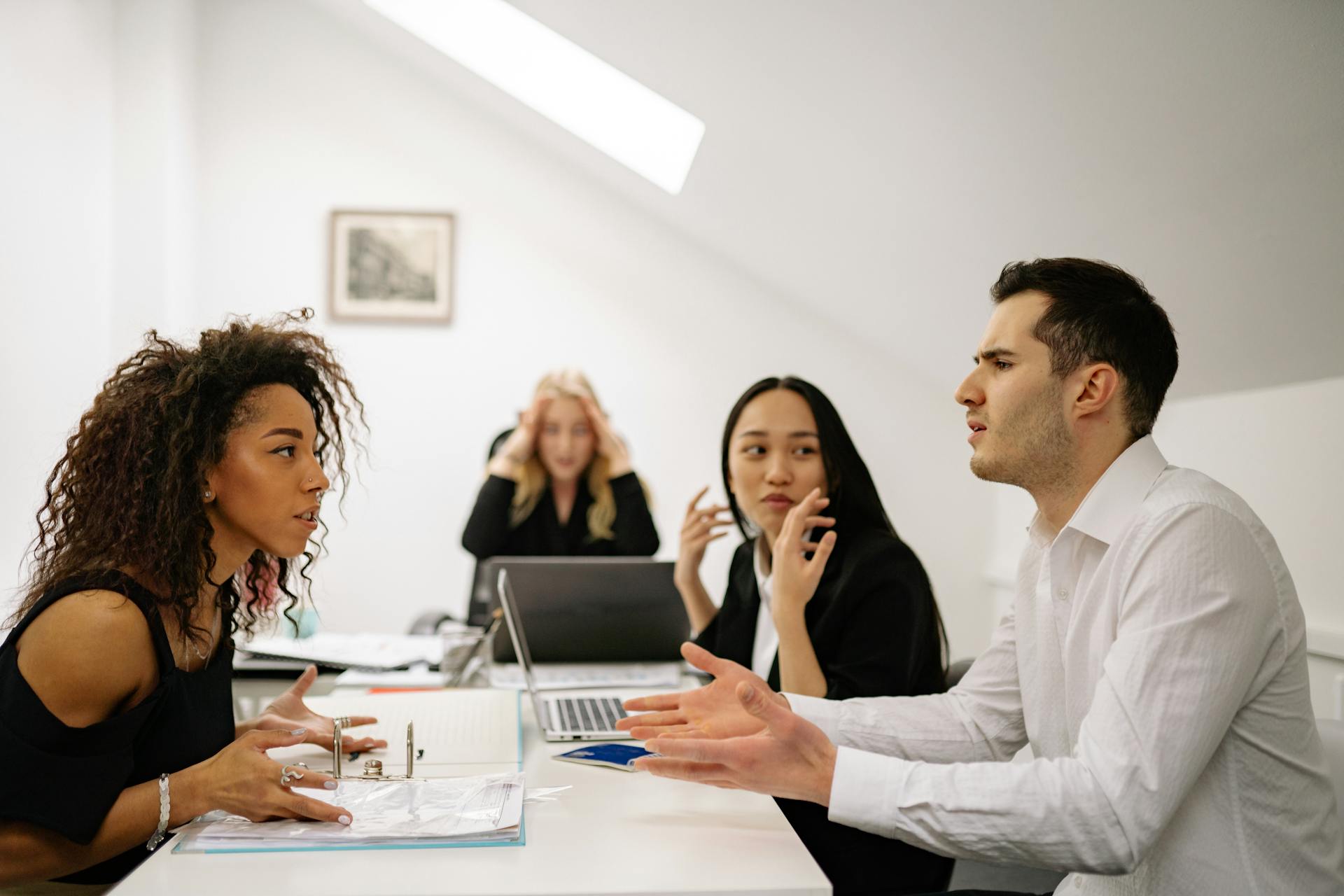 A multi-ethnic team engaged in a heated office discussion