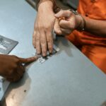 Close-up of fingerprinting during a criminal investigation with handcuffed individual