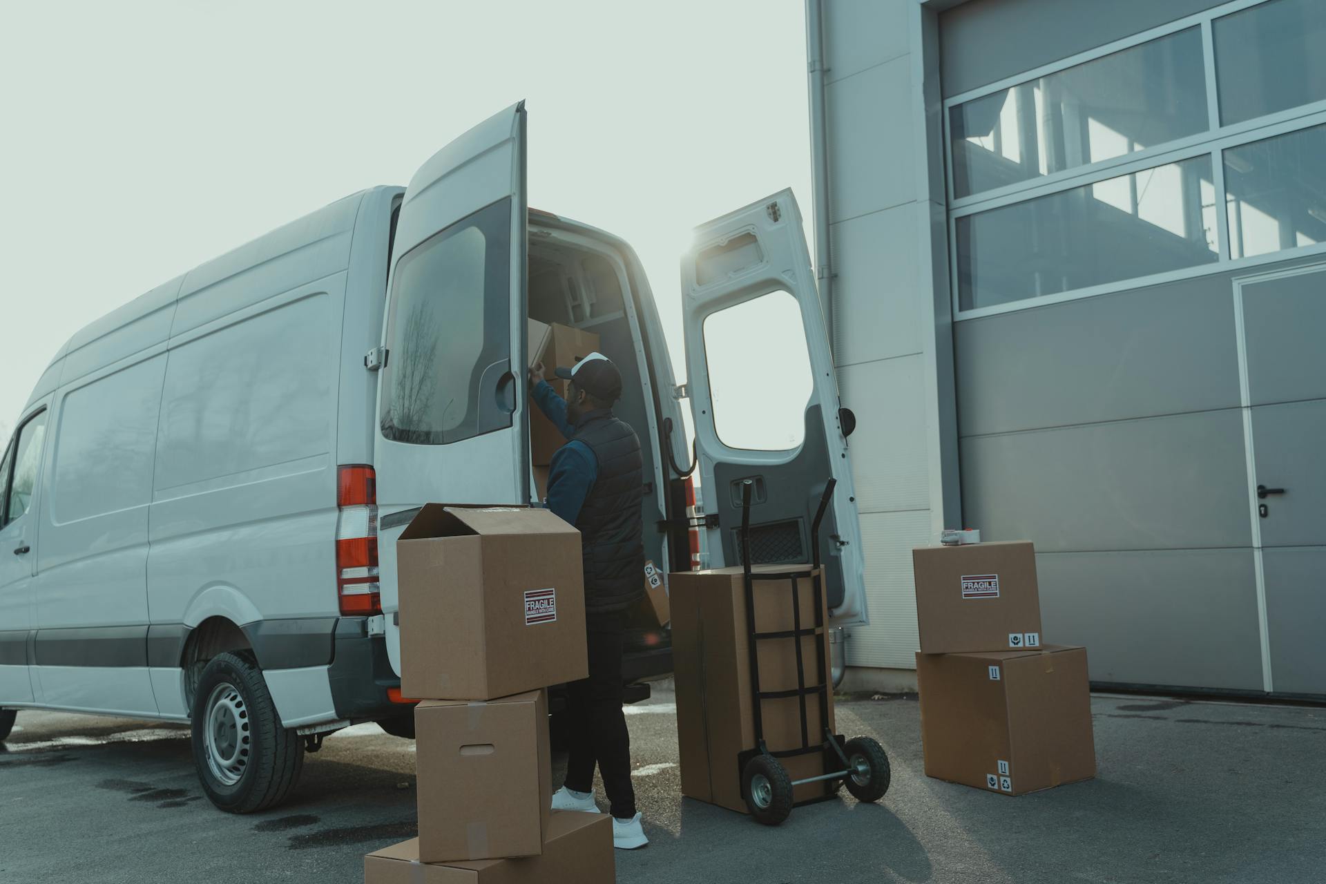 Courier loading cardboard boxes into a delivery