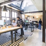 The Compliance Risks Employers Miss When Offices Become Hybrid 7 Employees working in a open office