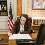 Female attorney in a law office signing legal documents at her desk