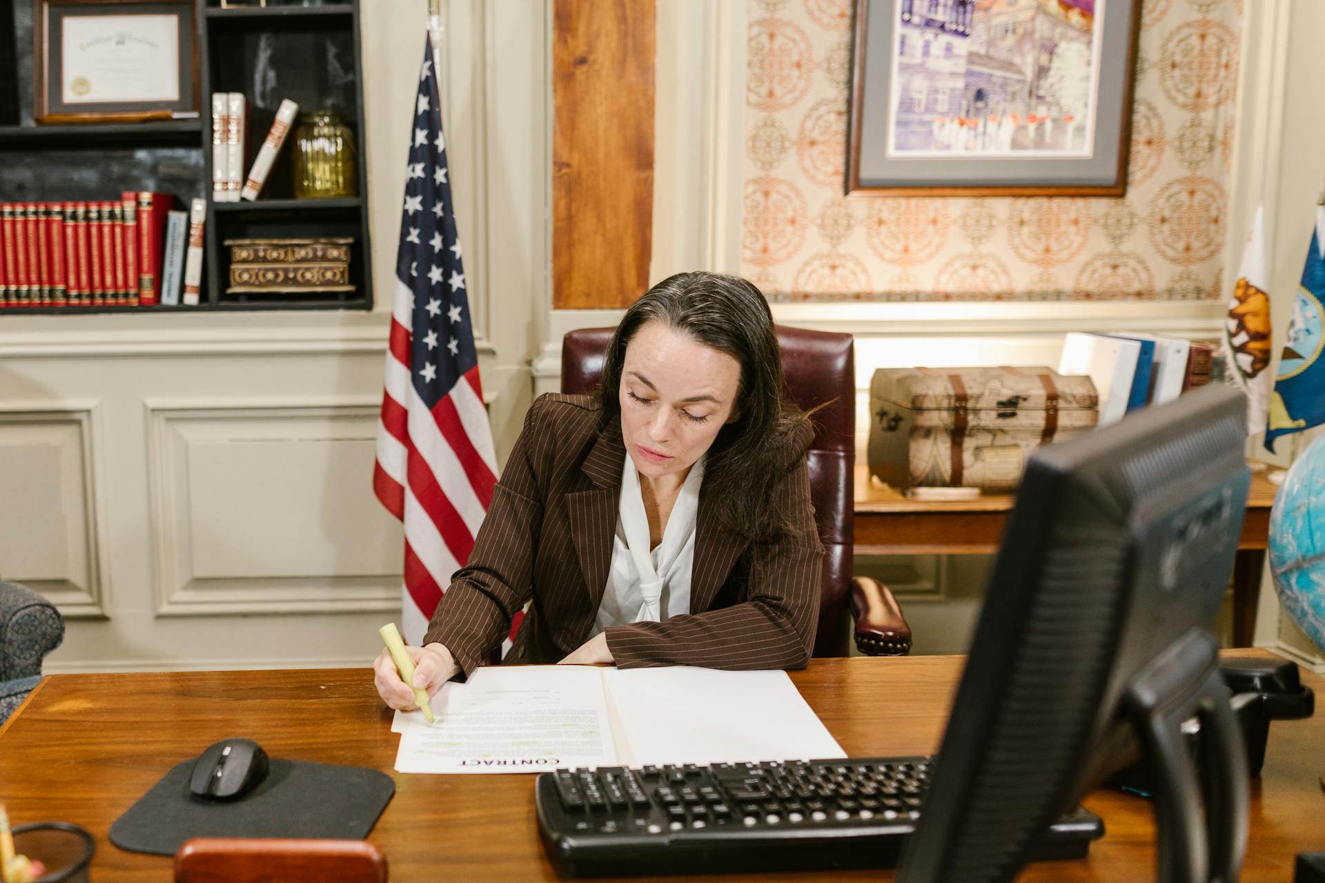 Female attorney in a law office signing legal documents at her desk