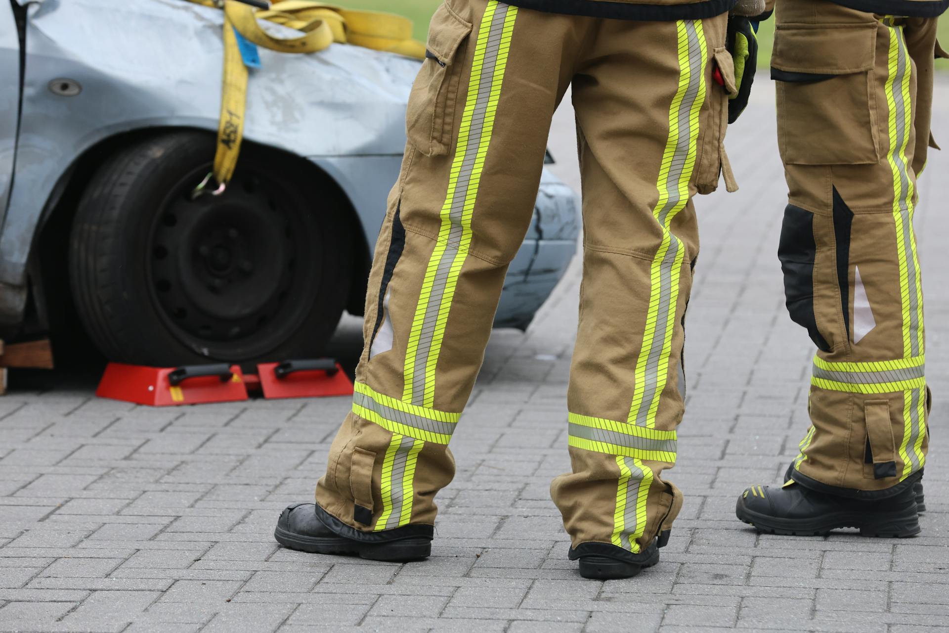 Firefighters inspecting a car accident wearing protective gear