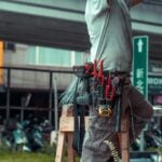 Handyman standing on a ladder with tool belt