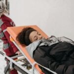 Medical personnel assisting a patient on a stretcher