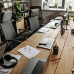 Why Employee Well-Being Starts With the Physical Workplace 7 Spacious co-working office with wooden desks, laptops, and modern chairs