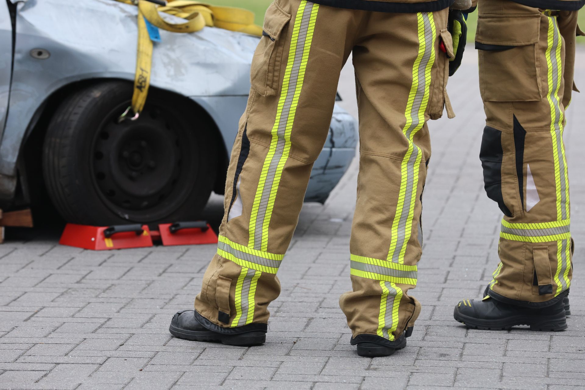 Firefighters inspecting a car accident wearing protective gear