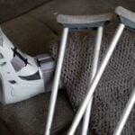 The Evidence That Can Make or Break a Personal Injury Claim: What Every Accident Victim Should Preserve 10 Close-up of an orthopedic boot and crutches on a couch, symbolizing injury recovery at home