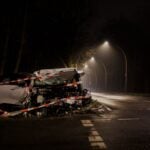 A wrecked car after a crash on a dimly lit street